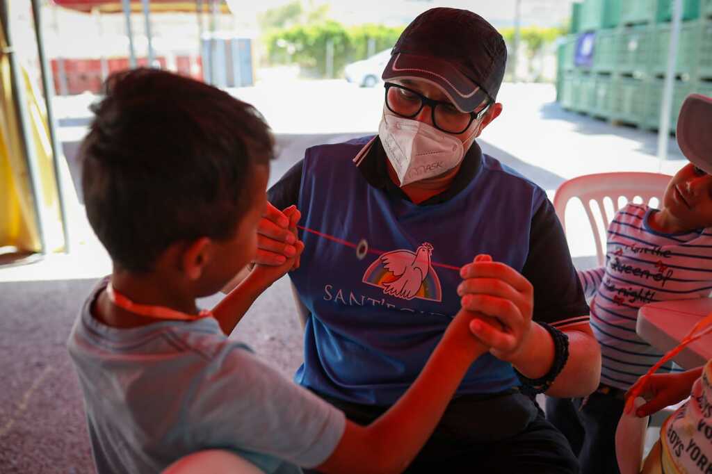 Alarma per calor a Lesbos, però a les carpes vermelles de Sant'Egidio els refugiats hi troben descans amb l'escola, aliments i amistat